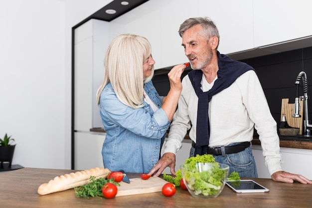 Kostenloses Foto mittlerer schuss mann, der tomate schmeckt