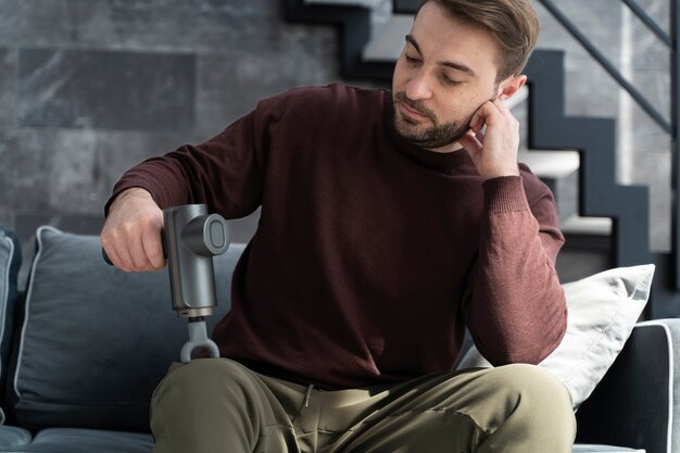 Mittlerer Schuss Mann mit Massagepistole drinnen