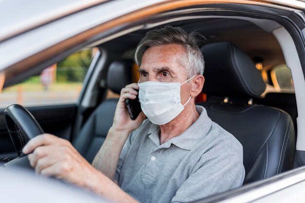 Mittlerer Schuss Mann mit medizinischer Maske fahren