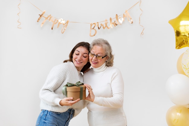 Mittlerer Schuss Smiley-Frauen mit Geschenk