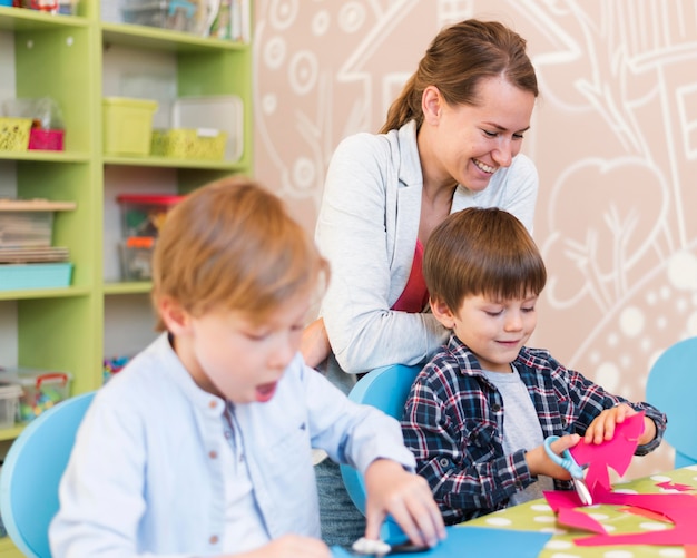 Mittlerer Schuss Smiley Lehrer beobachtet Kinder