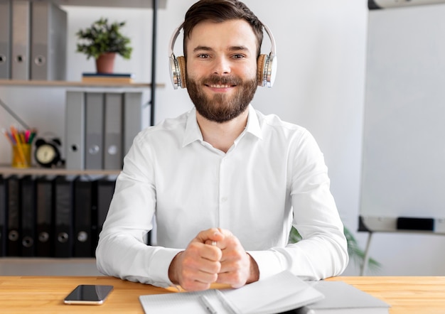 Kostenloses Foto mittlerer schuss smiley-mann am schreibtisch