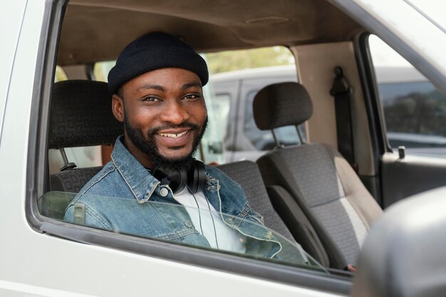 Mittlerer Schuss Smiley-Mann, der im Auto sitzt