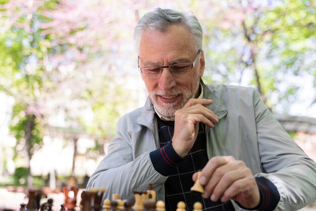 Mittlerer Schuss Smiley-Mann, der Schach spielt playing