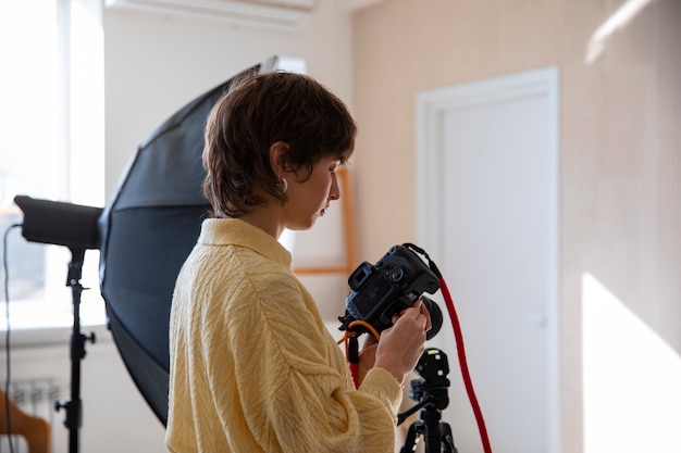 Kostenloses Foto mittlerer schuss spezialisierter fotograf, der fotos macht