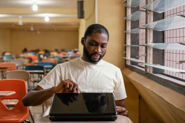 Mittlerer Schuss Student, der Laptop öffnet