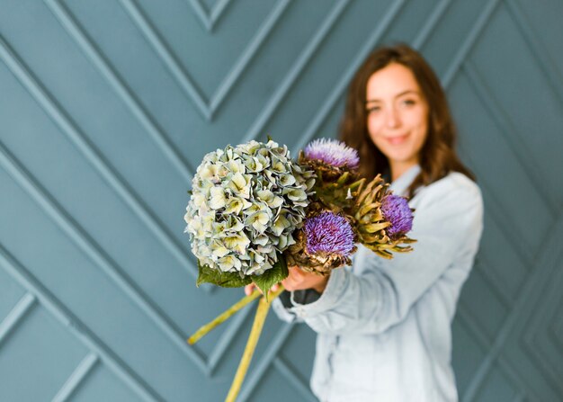 Mittlerer Schuss unscharfe Frau, die schönen Blumenstrauß hält