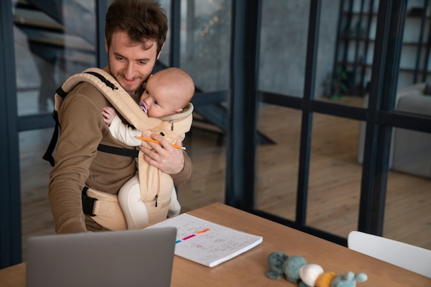 Bild eines Elternteils, der von zu Hause aus arbeitet, während das Baby schläft, als Beispiel für flexible Arbeitsarrangements während der verlängerten Elternzeit