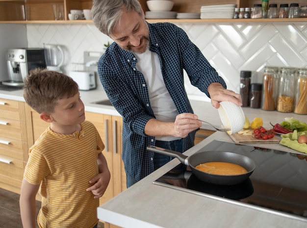 Mittlerer Schuss Vater, der Omelett kocht