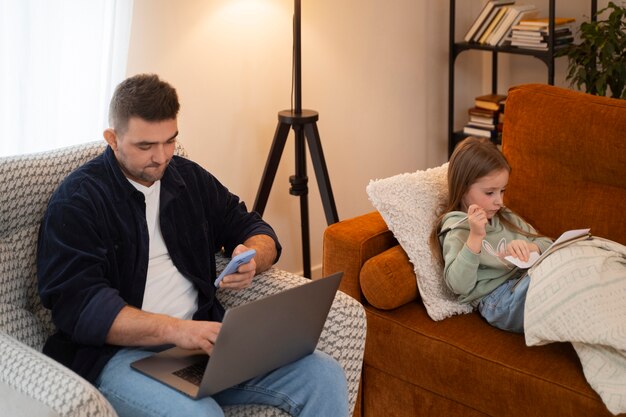 Mittlerer Schuss Vater, der zu Hause mit Kind arbeitet