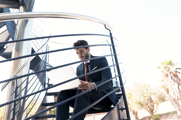 Mittlerer Schussarbeiter, der auf der Treppe sitzt