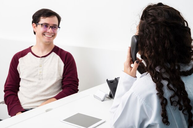 Mittlerer Schussdoktor, der am Telefon spricht