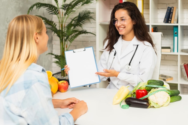 Mittlerer Schussdoktor, der dem Patienten Ergebnisse zeigt