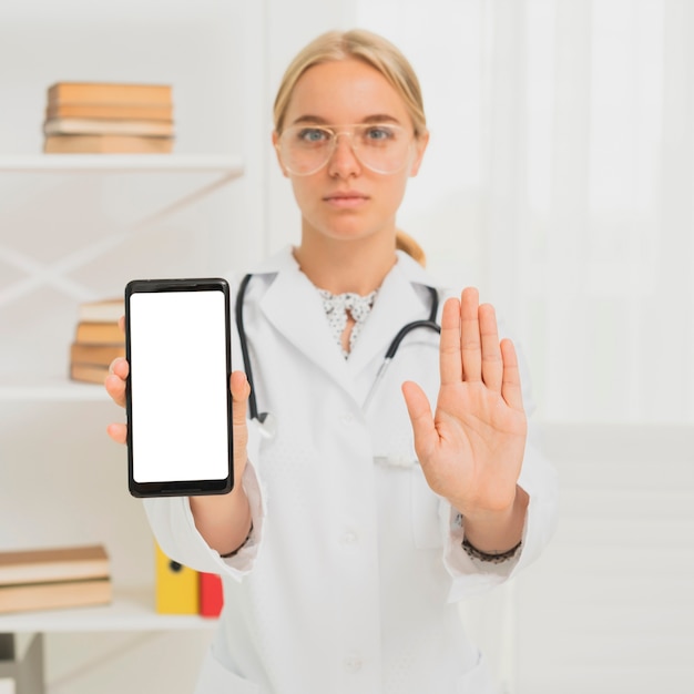 Kostenloses Foto mittlerer schussdoktor, der smartphone hält