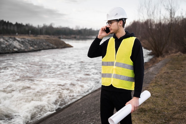 Mittlerer Schussingenieur, der draußen Plan hält