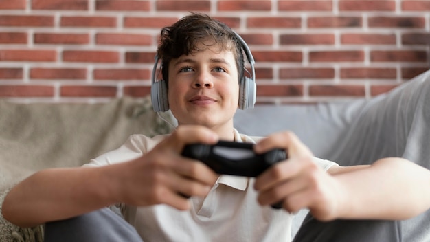 Mittlerer schussjunge, der mit controller spielt