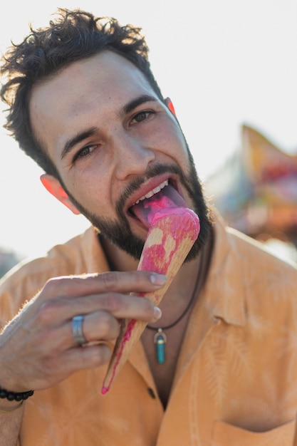 Mittlerer schusskerl mit dem braunen haar eiscreme essend