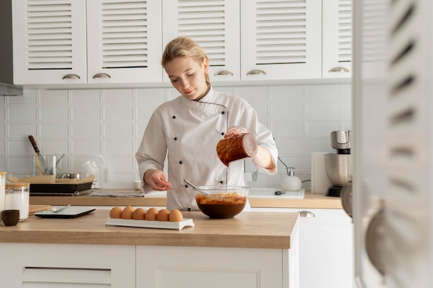 Kostenloses Foto mittlerer schusskoch, der in der küche kocht