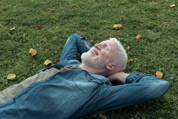 Kostenloses Foto mittlerer schussmann, der auf gras legt