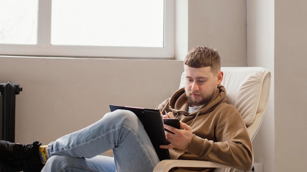 Kostenloses Foto mittlerer schussmann, der auf stuhl sitzt