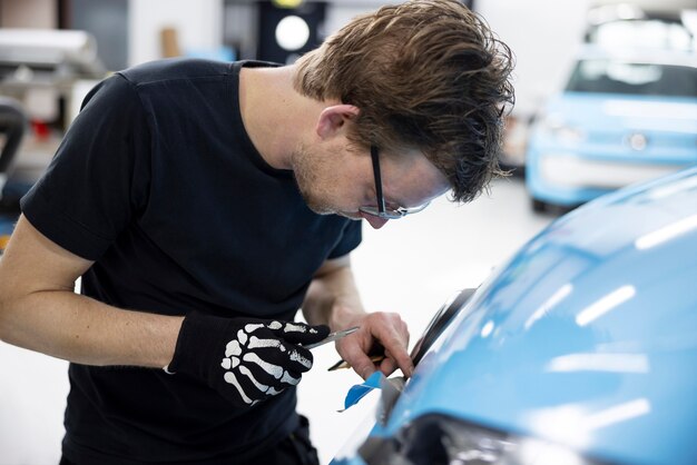 Mittlerer Schussmann, der Auto bei der Arbeit einwickelt