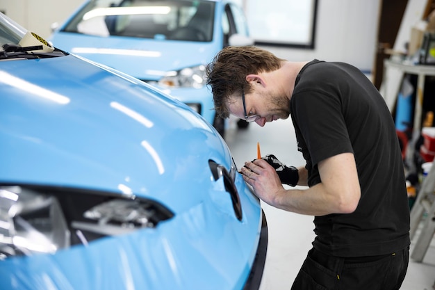 Mittlerer Schussmann, der Auto bei der Arbeit einwickelt