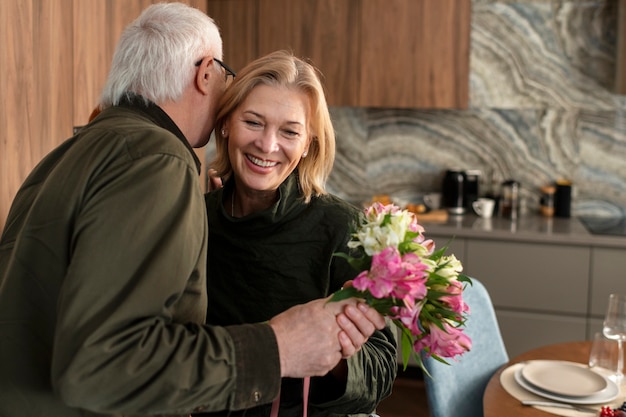 Kostenloses Foto mittlerer schussmann, der blumen anbietet