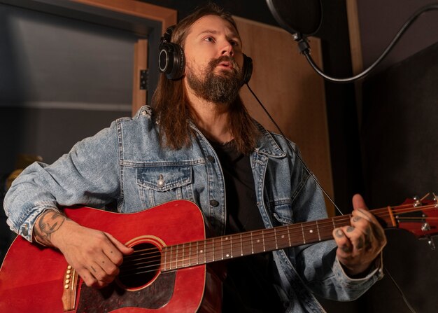 Mittlerer Schussmann, der die Gitarre im Studio spielt