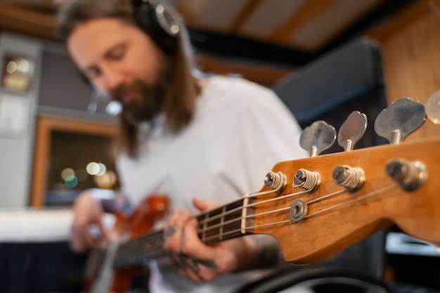 Mittlerer Schussmann, der die Gitarre im Studio spielt