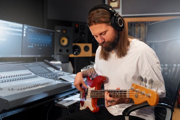 Mittlerer Schussmann, der die Gitarre im Studio spielt