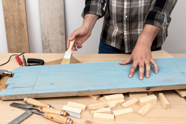 Kostenloses Foto mittlerer schussmann, der ein holz in blau malt