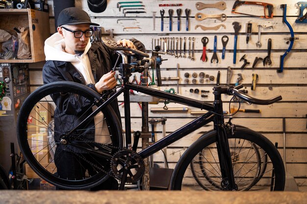 Mittlerer Schussmann, der Fahrrad im Laden repariert