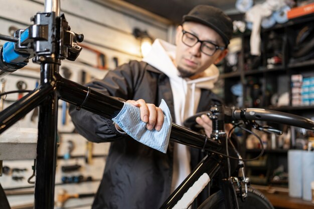 Mittlerer Schussmann, der Fahrrad putzt