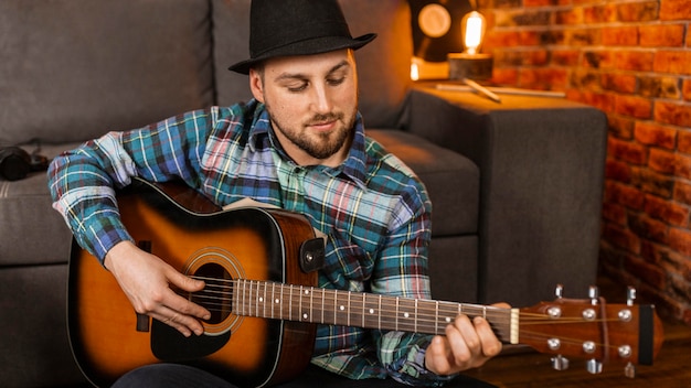 Kostenloses Foto mittlerer schussmann, der gitarre spielt