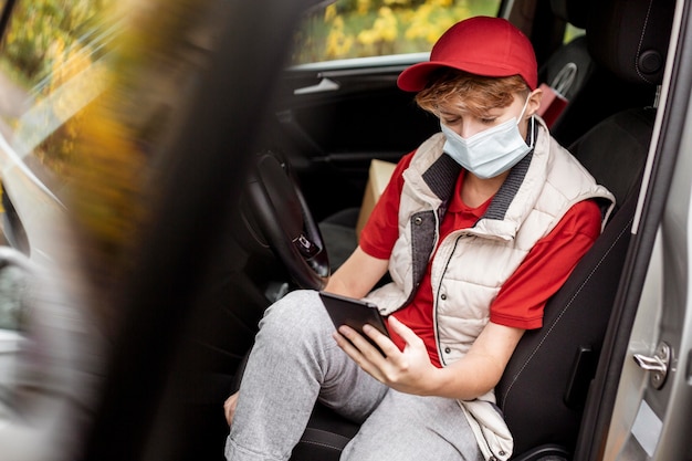 Kostenloses Foto mittlerer schussmann, der im auto sitzt