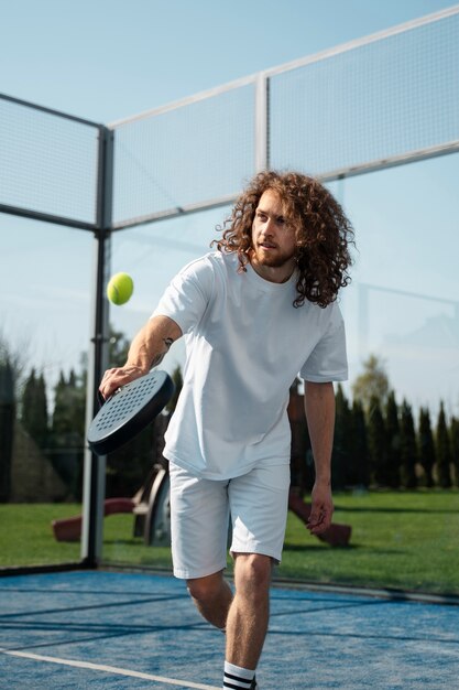 Mittlerer Schussmann, der Paddle-Tennis spielt