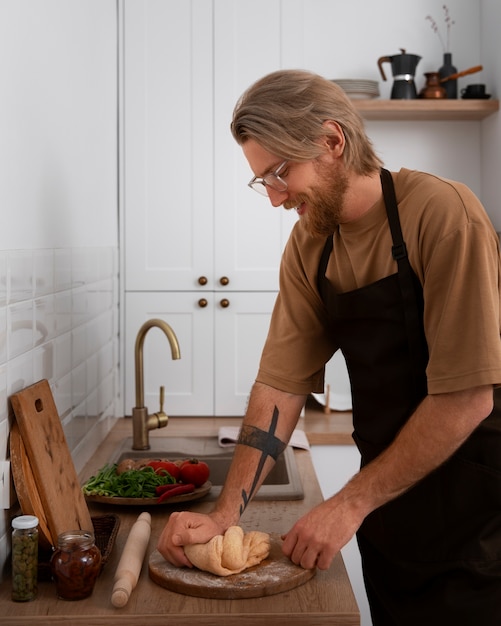 Kostenloses Foto mittlerer schussmann, der pizza kocht