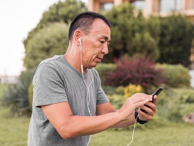 Mittlerer schussmann, der smartphone hält