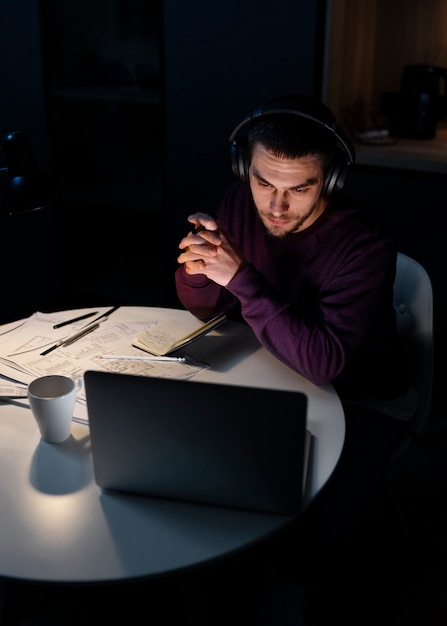 Mittlerer schussmann, der spät nachts am laptop arbeitet