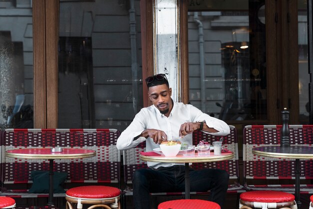 Mittlerer Schussmann im Bistro, das Essen schneidet