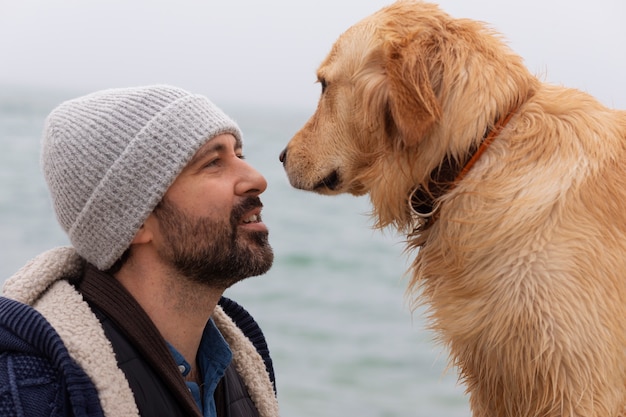 Kostenloses Foto mittlerer schussmann mit hund am meer