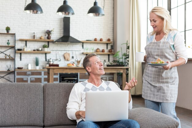 Mittlerer Schussmann mit Laptop sprechend mit Frau