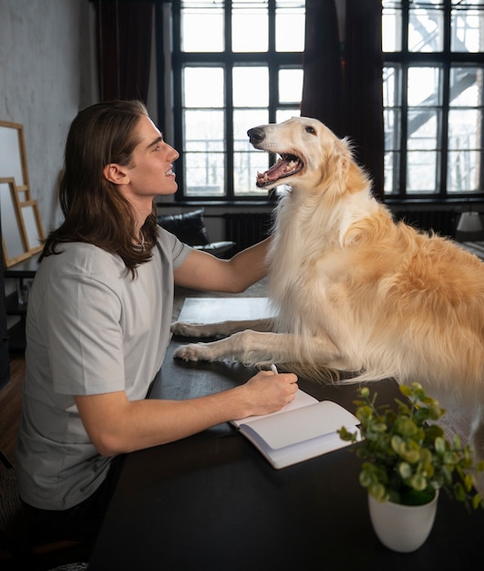 Kostenloses Foto mittlerer schussmann mit niedlichem windhundhund