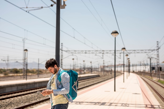 Kostenloses Foto mittlerer schussreisender, der telefon betrachtet