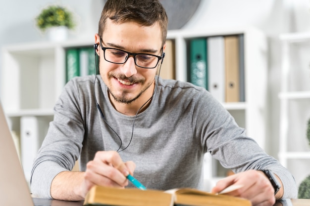 Mittlerer Schusssmileykerl, der mit Kopfhörern studiert