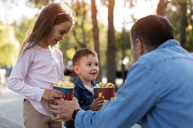 Kostenloses Foto mittlerer schussvater, der popcorn hält