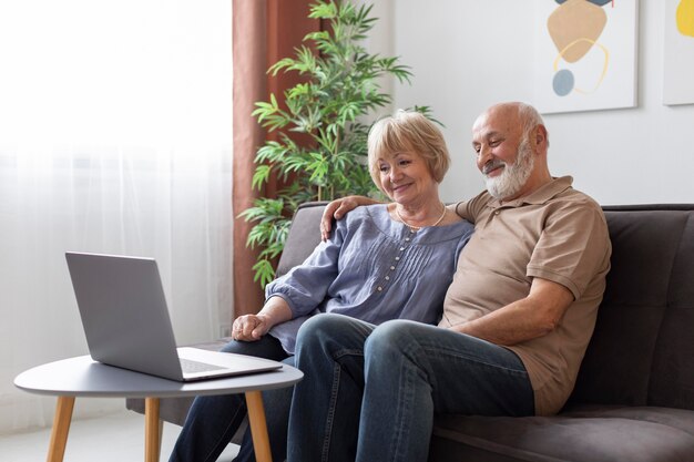 Mittleres Schuss älteres Paar, das auf Couch sitzt