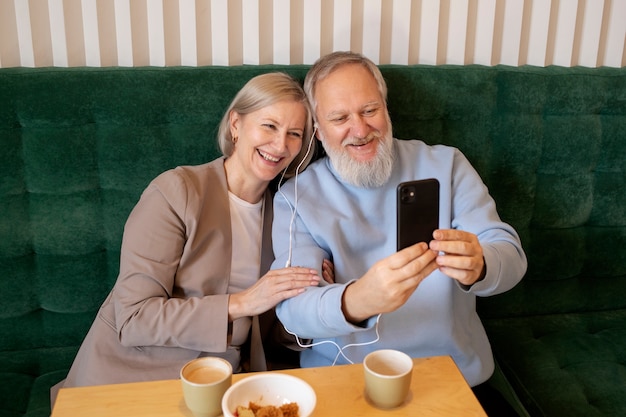 Kostenloses Foto mittleres schuss älteres paar, das selfie nimmt