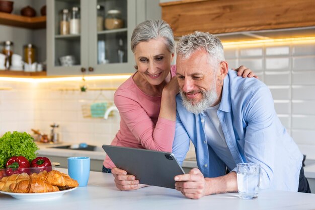 Mittleres Schuss älteres Paar mit Tablette