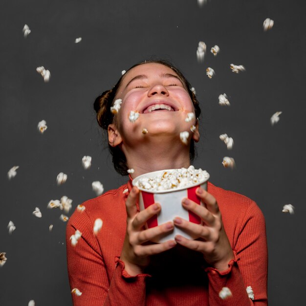 Mittleres Schuss glückliches Kind, das Popcorn hält